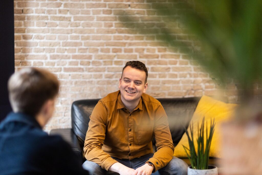 Maarten in gesprek met een klant in de lounge van het kantoor